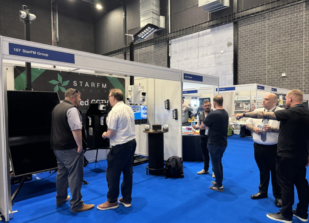 A photo of the StarFM Group team talking with interested attendees at the StarFM Group stand at Build North Expo